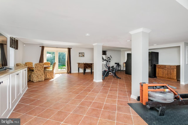 workout area featuring light tile patterned floors and decorative columns