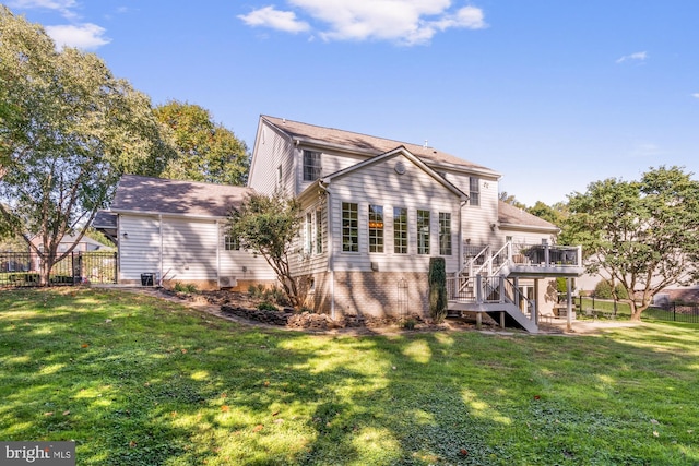 back of house featuring a wooden deck and a yard