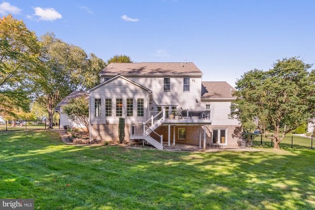 rear view of property with a wooden deck and a lawn