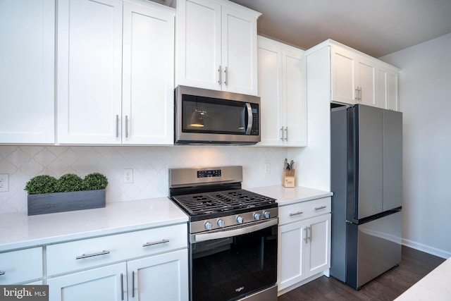 kitchen featuring appliances with stainless steel finishes, dark hardwood / wood-style floors, white cabinets, and backsplash