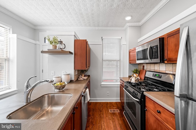 3100 E Lombard St, Baltimore, MD 21224 - kitchen with appliances with stainless steel finishes, a sink, ornamental molding, dark wood-type flooring, and backsplash
