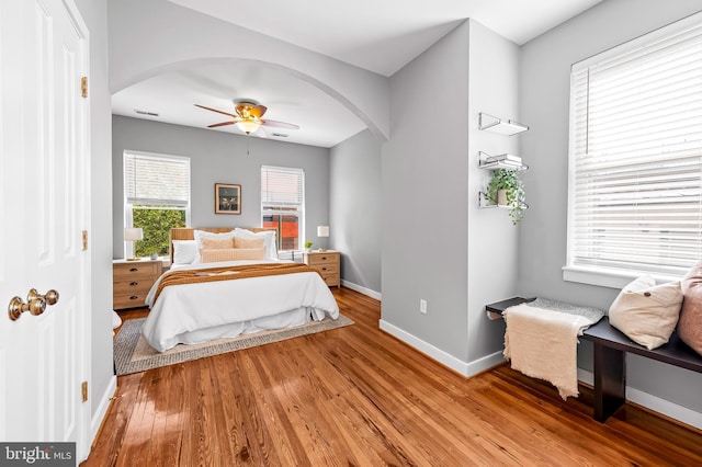 3100 E Lombard St, Baltimore, MD 21224 - bedroom with arched walkways, light wood-style floors, baseboards, and a ceiling fan
