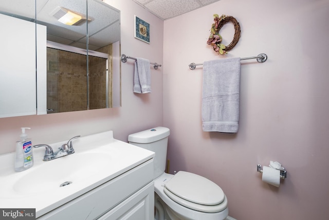 full bathroom with vanity, toilet, a paneled ceiling, and tiled shower