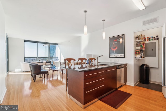 kitchen featuring dark countertops, visible vents, stainless steel dishwasher, a sink, and electric panel