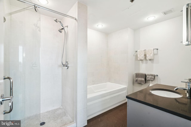 full bathroom featuring a stall shower, visible vents, vanity, and wood finished floors