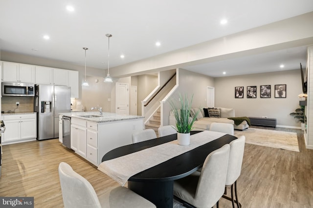 dining space featuring sink and light wood-type flooring