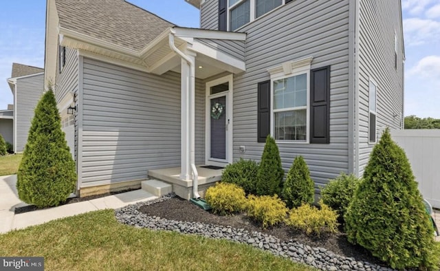 entrance to property featuring a garage and a yard