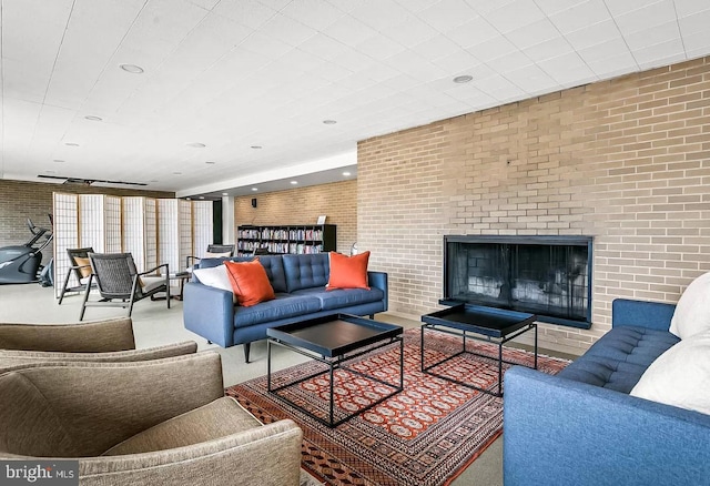 living room featuring brick wall and a fireplace