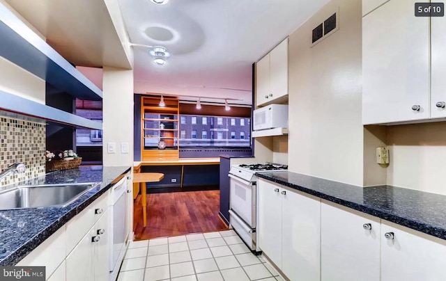 kitchen featuring sink, white appliances, white cabinetry, light tile patterned flooring, and decorative backsplash