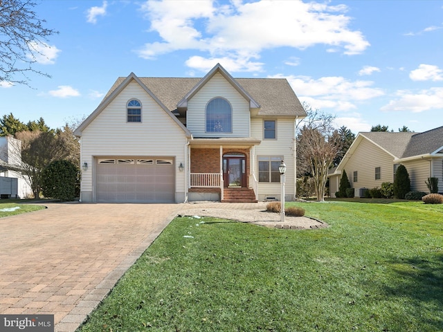 view of property featuring covered porch, a front lawn, and a garage