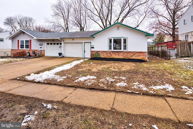 ranch-style home with a garage, driveway, brick siding, and fence