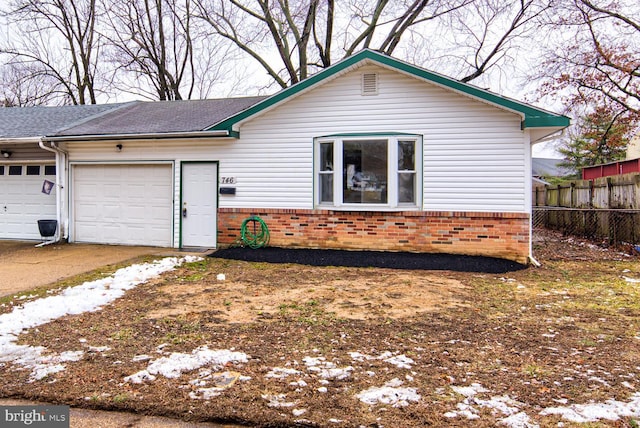 view of front facade with brick siding, fence, driveway, and an attached garage