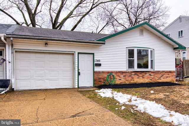 single story home with a garage, driveway, and brick siding