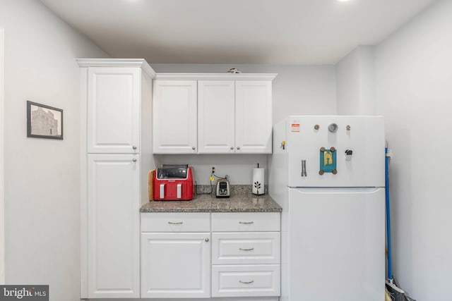 kitchen featuring white cabinetry and white fridge