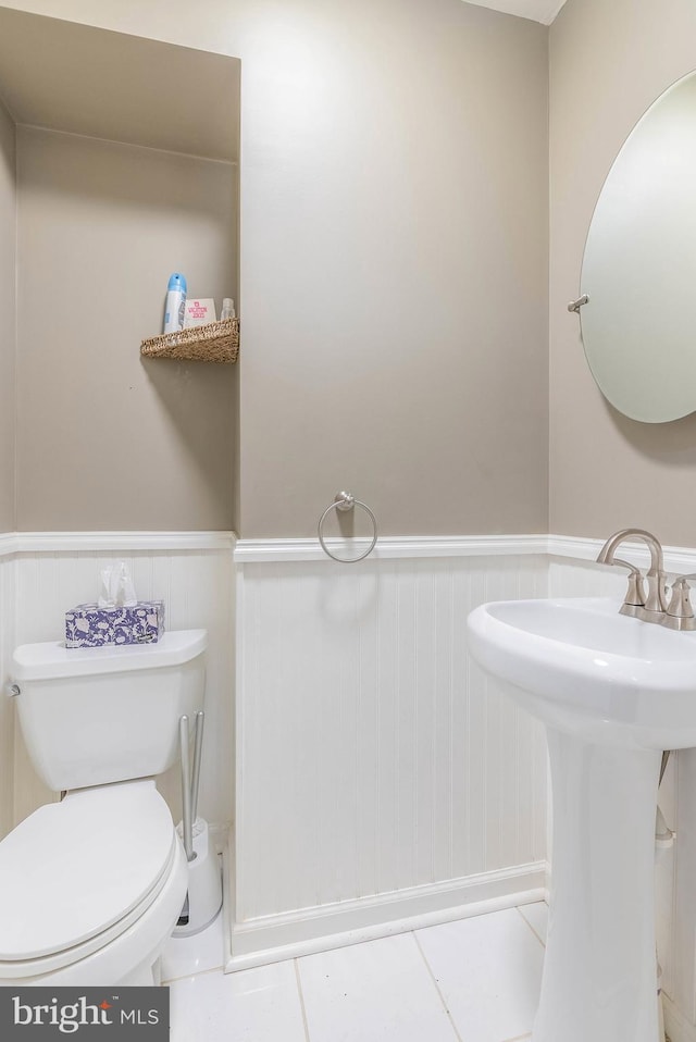 bathroom featuring sink, toilet, and tile patterned flooring