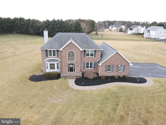 colonial home with a front lawn