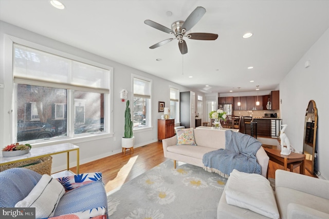 living room with recessed lighting, ceiling fan, light wood-style flooring, and baseboards