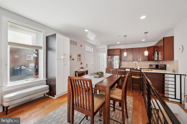 dining area with light wood-style floors and recessed lighting