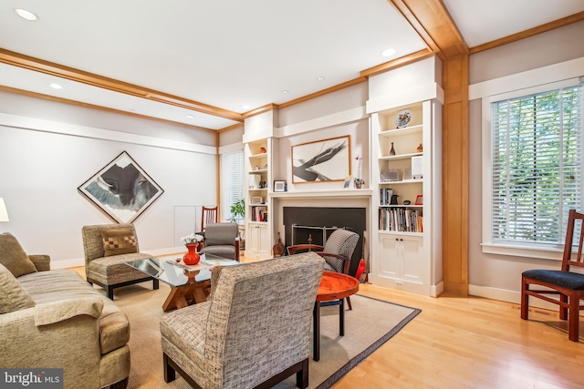 living room featuring crown molding, built in features, and light hardwood / wood-style flooring