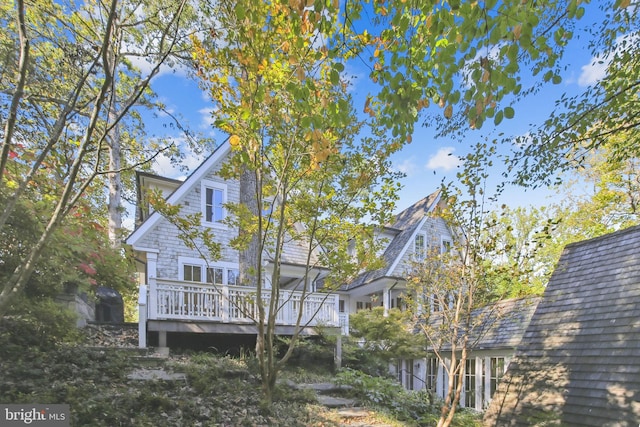 rear view of property featuring a wooden deck