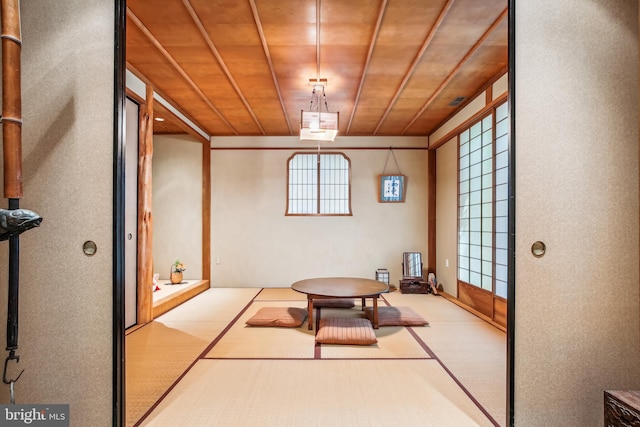 interior space featuring a healthy amount of sunlight, light colored carpet, and wood ceiling