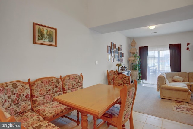 dining room with light carpet and light tile patterned floors