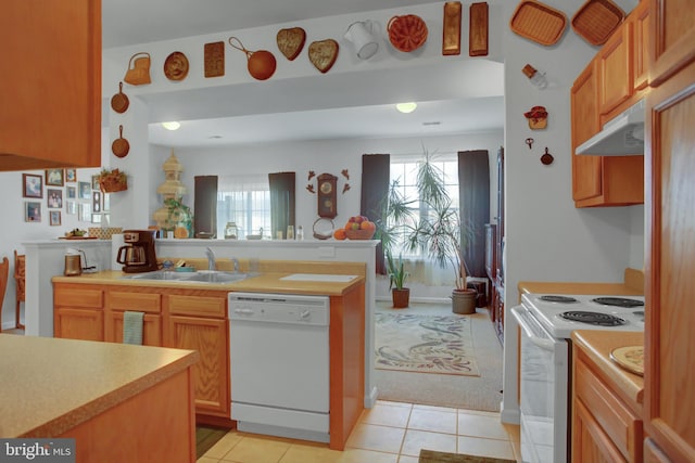 kitchen with light tile patterned floors, light countertops, a sink, white appliances, and under cabinet range hood