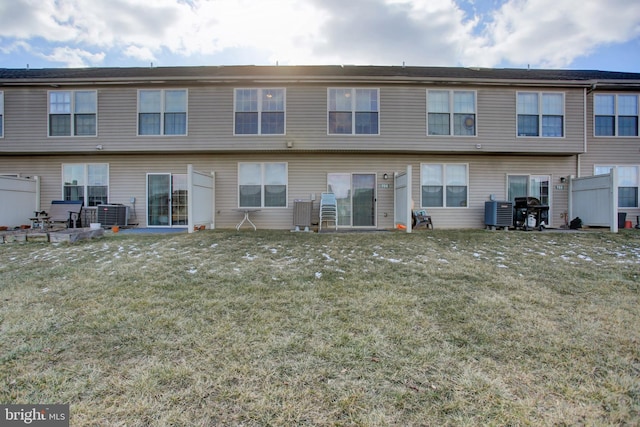 back of property with central AC and a yard