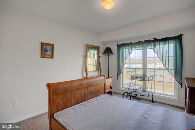 bedroom with carpet, multiple windows, and baseboards