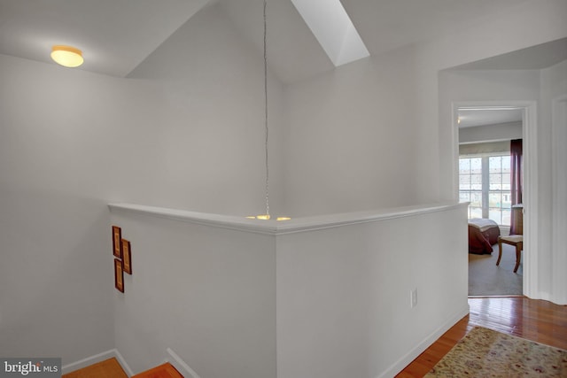 corridor featuring baseboards and wood finished floors