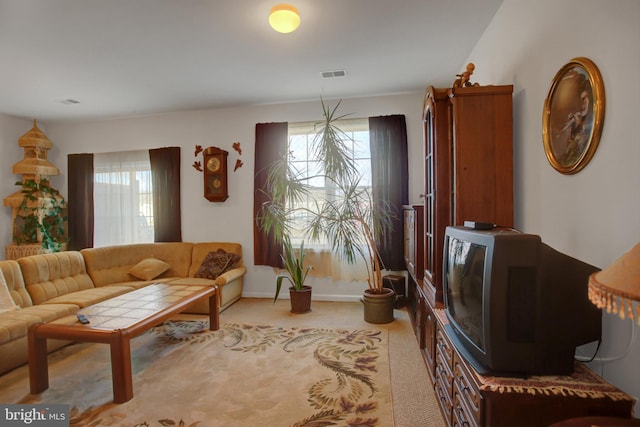 living area with light carpet, visible vents, and baseboards