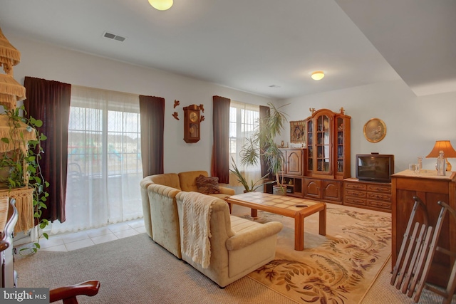 living area with light tile patterned flooring and visible vents