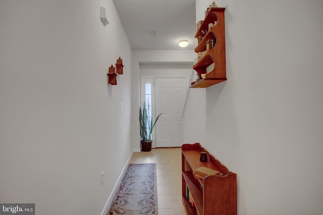 doorway with baseboards and light tile patterned floors