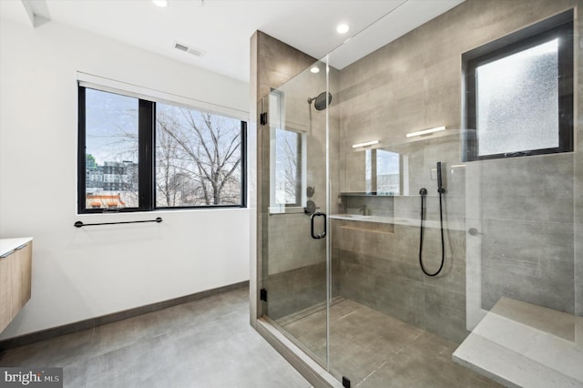 bathroom with a shower with door and concrete floors