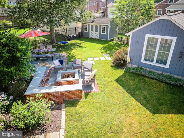 view of yard with a patio area, an outdoor fire pit, fence, and an outdoor structure