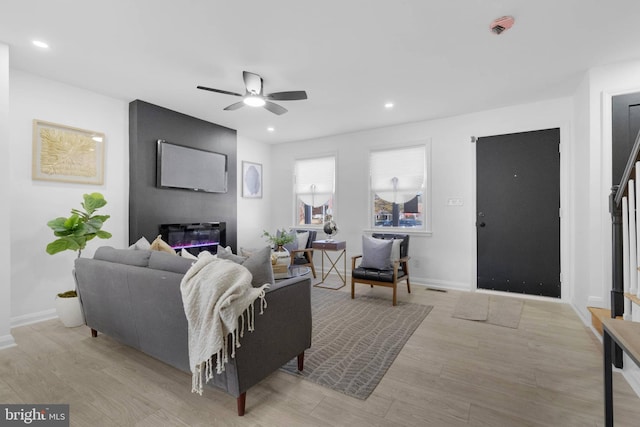 living room with ceiling fan and light hardwood / wood-style flooring
