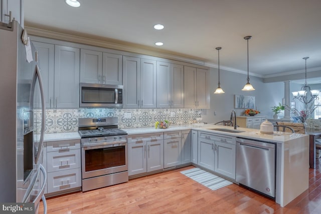 103 Candor Ln, Dover, DE 19901 - kitchen featuring ornamental molding, a peninsula, stainless steel appliances, light countertops, and a sink