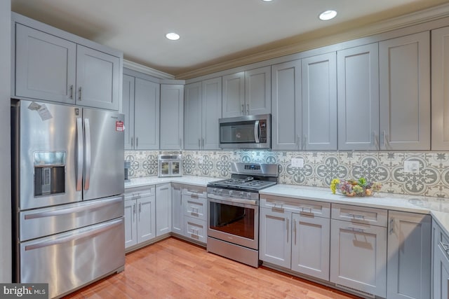 103 Candor Ln, Dover, DE 19901 - kitchen featuring decorative backsplash, stainless steel appliances, light countertops, gray cabinetry, and light wood-type flooring