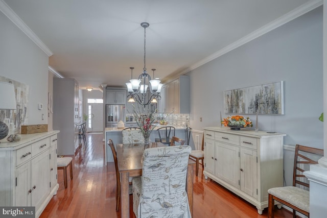 103 Candor Ln, Dover, DE 19901 - dining area featuring ornamental molding, a notable chandelier, and hardwood / wood-style floors