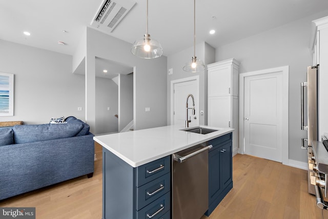 kitchen with a sink, visible vents, open floor plan, blue cabinetry, and stainless steel dishwasher