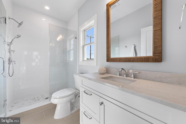 bathroom featuring a stall shower, tile patterned flooring, vanity, and toilet