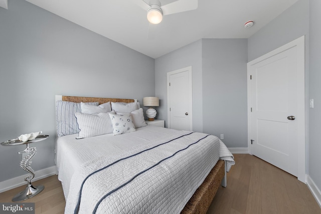 bedroom featuring wood finished floors, a ceiling fan, and baseboards