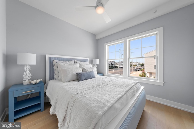 bedroom with wood finished floors, a ceiling fan, and baseboards