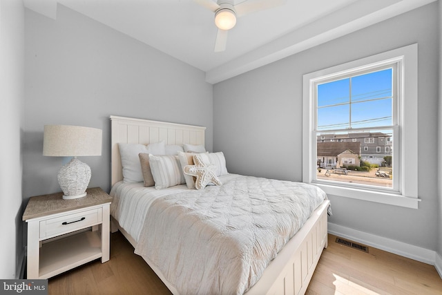 bedroom featuring visible vents, ceiling fan, light wood-style flooring, and baseboards