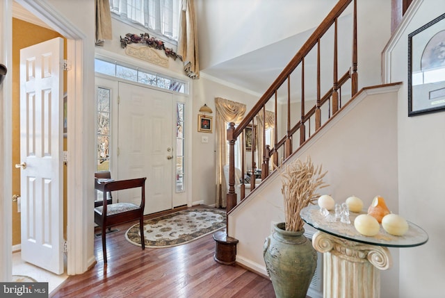 entrance foyer with a towering ceiling and wood-type flooring