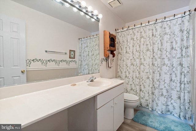 bathroom with vanity, curtained shower, toilet, and hardwood / wood-style flooring