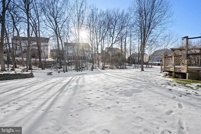 snowy yard featuring a wooden deck