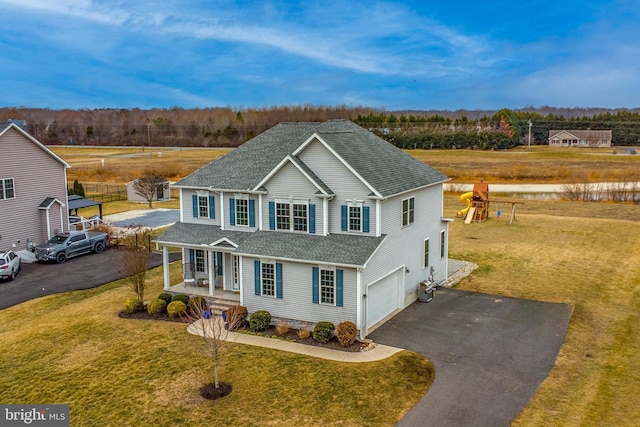 view of front of property with a garage, covered porch, and a front lawn