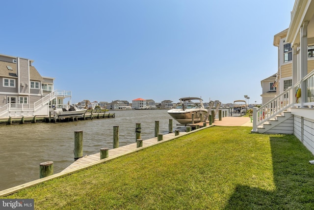 dock area with a lawn and a water view