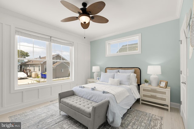 bedroom with multiple windows, ornamental molding, light hardwood / wood-style floors, and ceiling fan